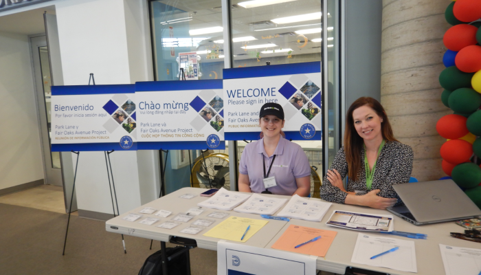 Two Bartlett & West employee-owners pose for a picture at a table during a public meeting